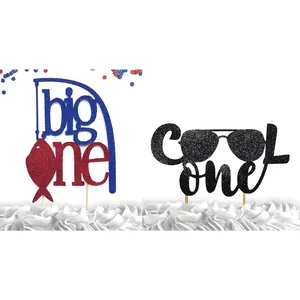 Glittery 'Big One' fishing and 'Cool One' pilot sunglasses cake toppers for 1st birthday