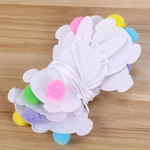Easter bunny banner with white felt rabbits and colorful pom-poms on wooden background