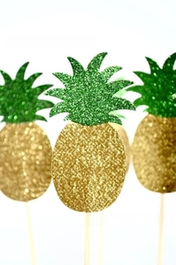 Detail of glitter pineapple cake toppers with golden fruits and green leaves