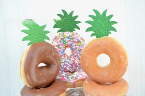 Detail of green glitter pineapple leaf cake toppers for tropical birthday party decor