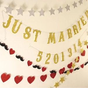 Close-up of golden Just Married and 5201314 banners with glitter heart and star garlands