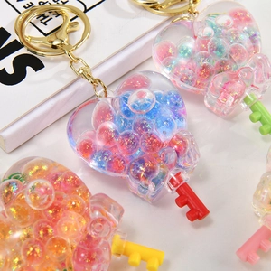 Close-up of heart-shaped acrylic keychains with colorful glitter beads and metal rings