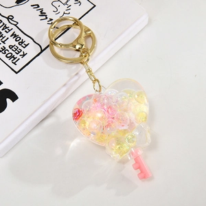 Close-up of heart-shaped acrylic shaker keychain with pink liquid and golden metal ring