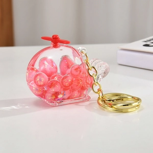 Detailed close-up of helicopter keychain with pink glitter beads and gold chain