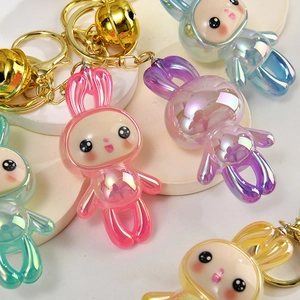 Close-up of cute acrylic bunny keychains with pearlescent finish and golden metal bells