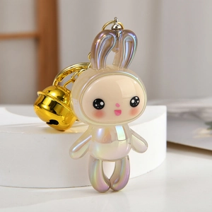 Macro view of iridescent acrylic bunny keychain with gold bell and metallic clip