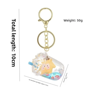 Detail showing creative milk tea cup shaker keychain with yellow star doll and blue liquid