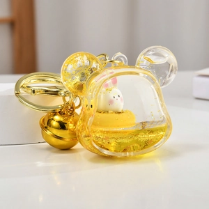 Detail of Mickey-shaped liquid keychain with golden sand and cute rabbit toy inside