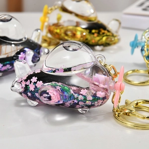 Macro detail of acrylic airplane keychain with floating cherry blossoms and blue star sequins