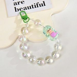 Macro detail of acrylic beaded chain with green mermaid charm and metallic lobster clasp