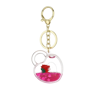 Heart-shaped acrylic keychain with red rose and floating pink heart sequins inside
