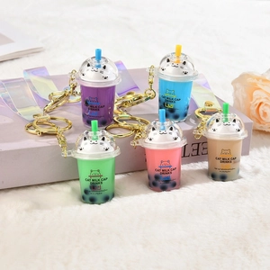 Detailed set of five colorful cat bubble tea cup keychains on soft white faux fur