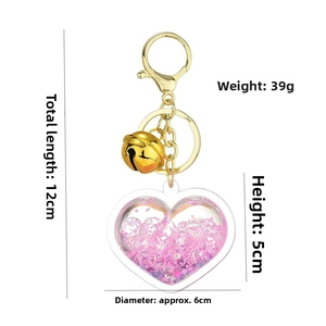 Detail showing dimensions of heart-shaped acrylic glitter keychain with golden bell