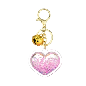 Luminous heart-shaped liquid acrylic keychain with pink sequins and gold bell accessory