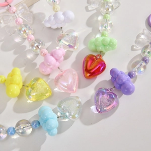 Close-up of colorful iridescent acrylic heart and bow charms for DIY bag accessories