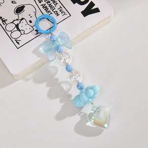 Close-up of blue heart-shaped acrylic bead charm and cute bow keychain accessory