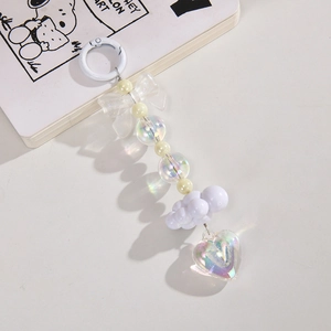 Close-up of white bow and iridescent heart pendant keychain with beaded details