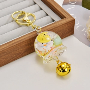 Détail du porte-clés canard de dessin animé avec cloche dorée et coque en résine