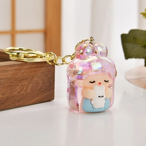 Cute acrylic bear keychain with iridescent finish and a mini doll figure charm