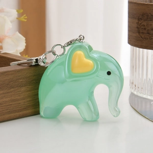 Detail of mint green elephant keychain with yellow heart and silver lobster clasp