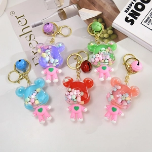 Close-up of colorful liquid-filled bear keychains with hearts and small bells