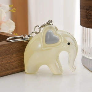Cute translucent beige elephant keychain with gray heart detail and silver metal clasp