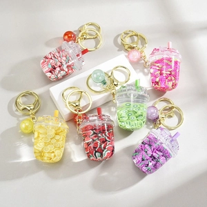 Detail of colorful fruit-themed liquid beverage keychains with gold clasps and glitter charms