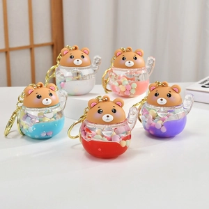 Detail of five colorful bear-shaped liquid keychains with acrylic beads and gold rings