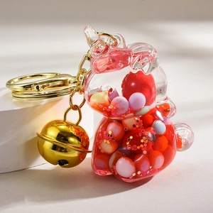 Detail of unicorn acrylic keychain featuring colorful beads, pink sequins, and golden bell