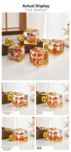 Macro view of clear resin cube keychain with red mouse figurine and gold foil flakes
