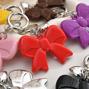 Close-up of colorful acrylic bow keychains with heart charms in various vibrant shades