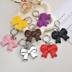 Colorful acrylic bow keychain set with metallic heart pendants in various vibrant colors