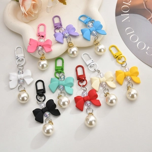 Nine colorful bowknot keychain pendants with matte finish and elegant faux pearls