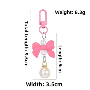 Detail of pink bow keychain with large pearl, D-ring buckle, and size dimensions
