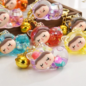 Detail of colorful cat-shaped quicksand keychains with sequins and golden bells