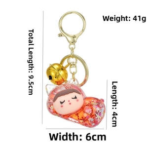 Close-up of cute cartoon girl liquid sand keychain with glitters and golden bell