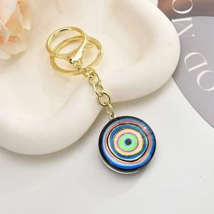 Macro view of a colorful evil eye charm with gold lobster clasp and round key ring