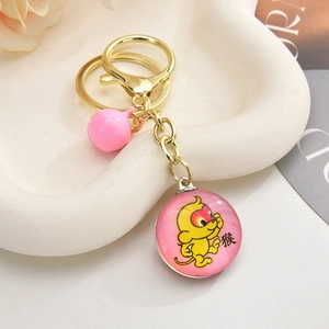 Close-up of pink 3D monkey keychain with gold ring, bell and Chinese zodiac pendant