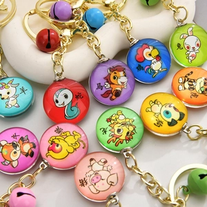 Close-up of colorful 3D zodiac keychains with gold-plated charms and vibrant metal bells