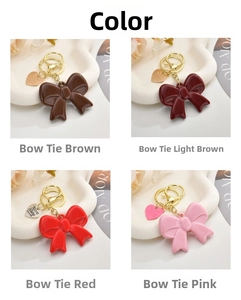 Detail of acrylic bow keychains in four colors with gold lobster clasps and heart tags