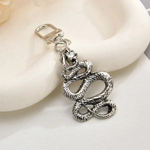 Macro view of vintage silver snake keychain showing detailed scale texture and metal ring
