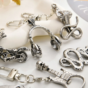 Macro view of vintage silver zinc alloy charms featuring skull guitar and cobra details