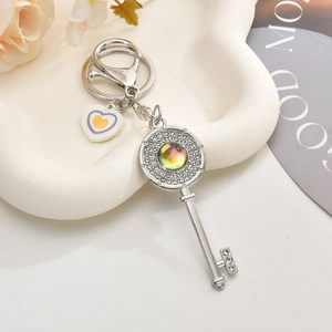Detail eines silbernen Schlüsselanhängers mit Strasssteinen und Herz-Charm