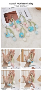 Detail of liquid bear keychain charms featuring acrylic tulips and heart lock designs