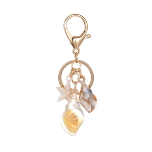 Nautical keychain with beige starfish, marble shell, and sand-filled conch on gold clip