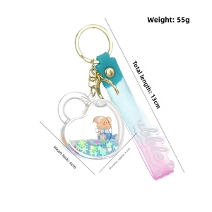 Close-up of heart liquid keychain with bear figurine and blue glitter star sand