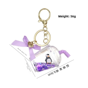 Detail of purple penguin liquid sand keychain with cup dimensions and golden heart charm