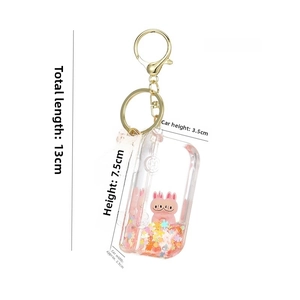 Detail of acrylic oil sand keychain with pink bunny and golden Love charm accessory