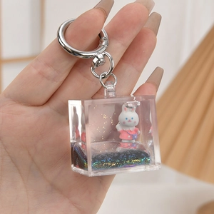 Close-up of acrylic liquid quicksand keychain with cute cartoon bunny and pink glitter