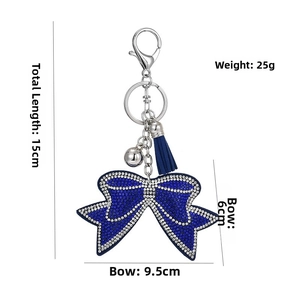 Detail view of a blue rhinestone bow keychain with tassel and size specifications
